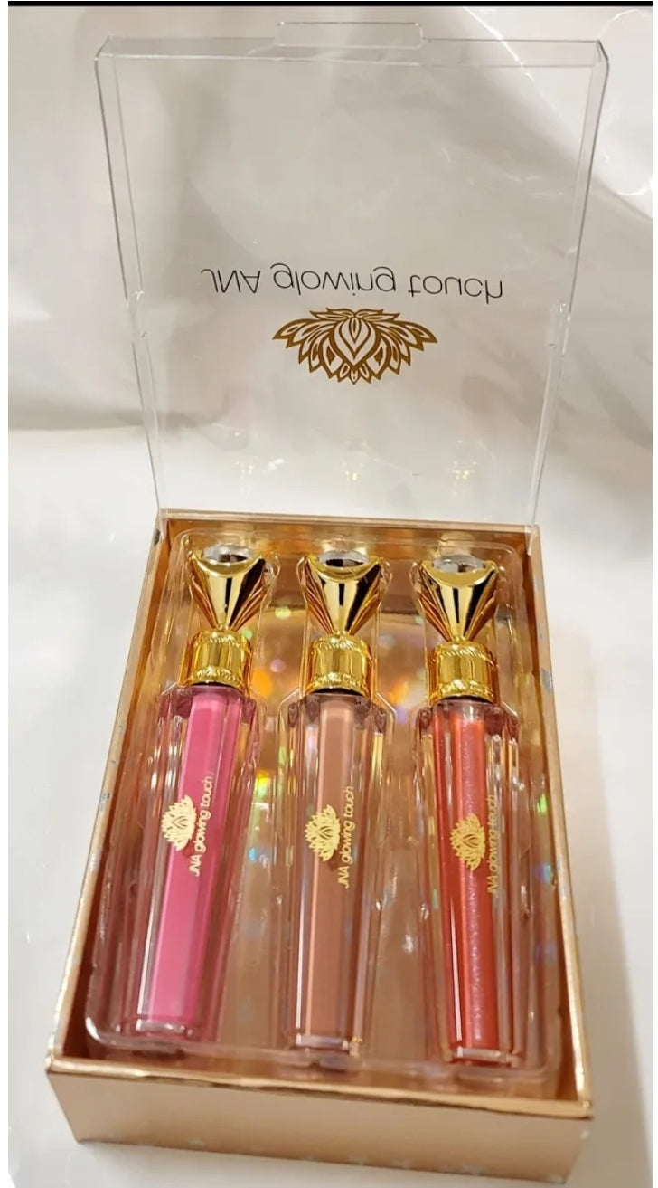 Luxury set of JNA glowing touch lipgloss in a gold box.