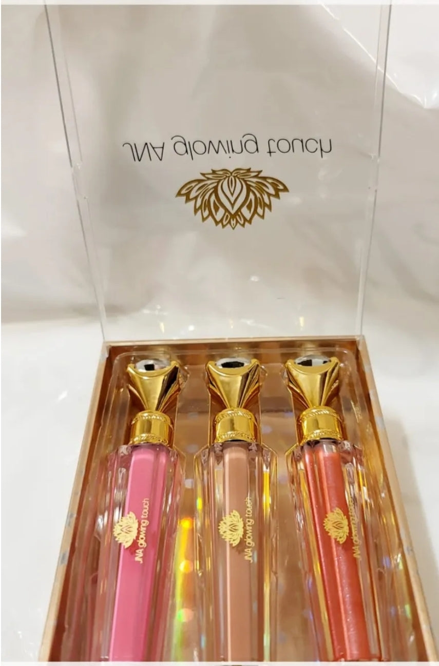 Luxury set of JNA glowing touch lipgloss in a gold box.