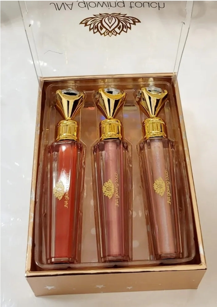 Luxury set of JNA glowing touch lipgloss in a gold box.