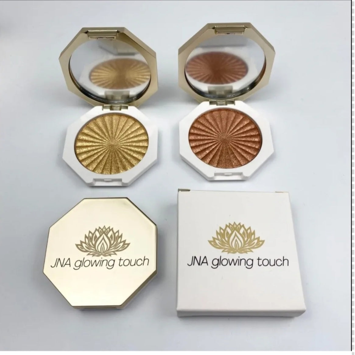 JNA glowing touch highlighter set in gold and bronze compact form.