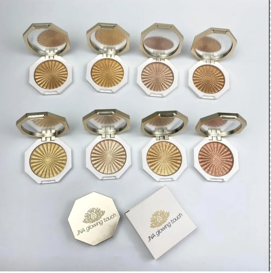 JNA glowing touch highlighter set in gold and bronze compact form.