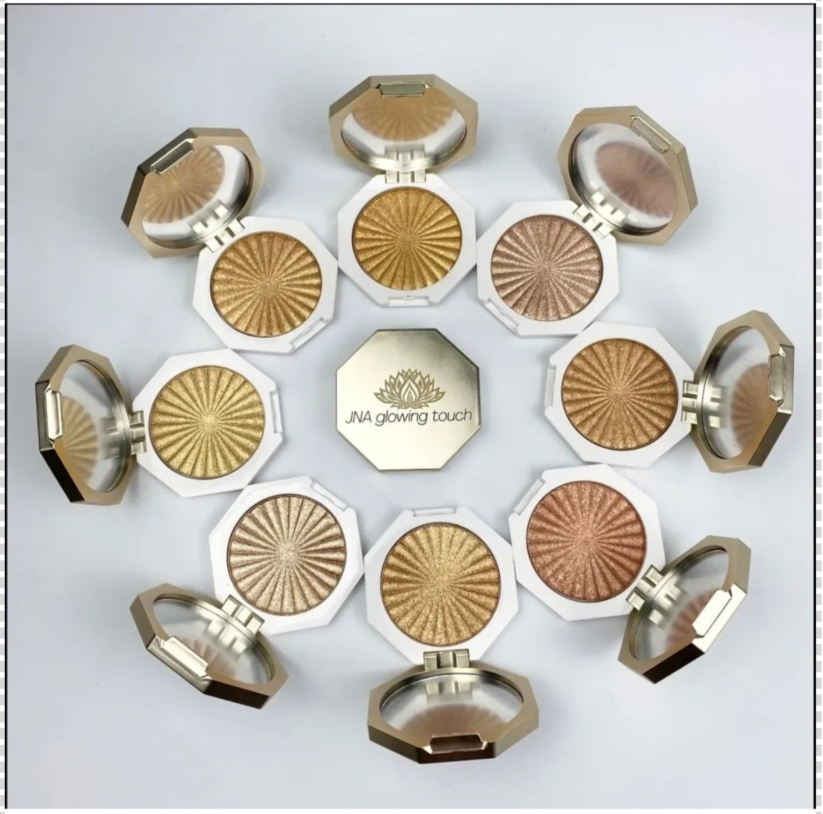 JNA glowing touch highlighter set in gold and bronze compact form.